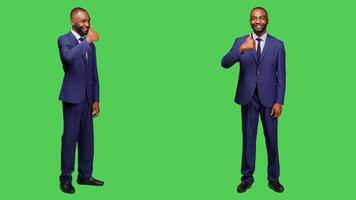 Smiling startup worker showing thumbs up sign and expressing approval in studio, full body greenscreen. Corproate manager feeling confident and positive, doing like and okay symbol. photo