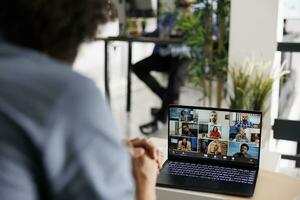 Project manager collaborating on strategy with corporate workers through online meeting on laptop. Entrepreneur discussing start up idea with colleagues in virtual conference photo