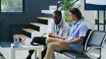 Specialist using medical insturment to check asian man blood sample, measuring insulin and glucose level during checkup visit consultation in hospital waiting area. Medicine support service photo