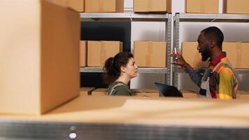 Diverse people reviewing supply chain in storage room, looking at products logistics on tablet. Team of employees working in manufacturing small business, quality control verification. photo