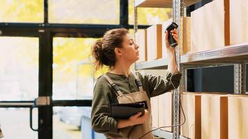 Supervisor scanning barcodes on racks, working on cargo inspection and verification in warehouse. Reviewing boxs of products and checking inventory list, preparing order delivery with scanner. photo