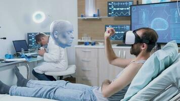 Patient laying in clinic bed wearing virtual reality headset, seeing holographic AR visualization of his mind while doctor monitors his brainwaves activity, studying brain information photo