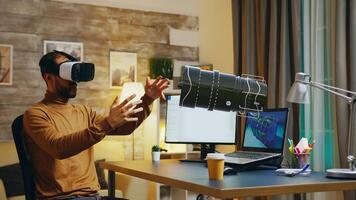 Freelancer in home office wearing VR goggles using AR hologram to visualize end result. Specialist working on machinery construction using cad engineering software, developing turbine components photo