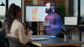 Worker watching augmented reality training video visualization of team leader explaining how to solve tasks at innovative office desk computer. African american employee with hologram manager photo