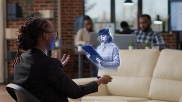 Team leader in AR teleconference meeting in innovative office greeting regional manager, showing team project progress. Employee in coworking space holding holographic online videocall with management photo