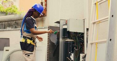 calificado electricista oficial por hogar propietario para anual aire acondicionador rutina mantenimiento, utilizando suave limpiar el polvo cepillo a limpiar sucio condensador bobinas y filtros, al aire libre foto