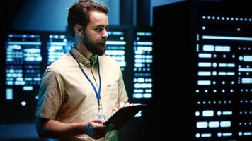 Developer in server room walking through data hardware clusters used for computationally intensive tasks such as scientific simulations or 3D rendering. Programmer doing computing software updates photo