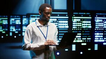 African american specialist ensuring server farm systems provide redundancy, automatic failover and rapid reconfiguration of clusters to minimize failure of individual machines photo