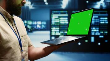 Specialist using green screen laptop to check server clusters configuration settings, close up. Engineer checking event logs in monitoring software to find faulty data center hardware root cause photo