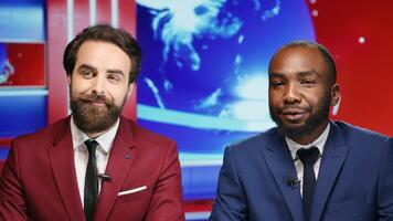 Morning show hosts talk about daily events in news studio, presenting breaking news segment early at breakfast. News anchors diverse team discussing like on global television program. photo