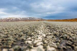 Long road through nordic landscape with lonely wayside, frosty farmland, and ice covered pastures in Iceland. Stunning overview of northern region and icy mountains, scandinavian highway. photo