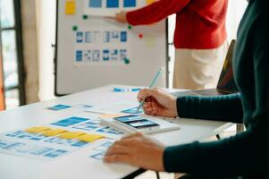 vista de cerca del equipo de desarrolladores de ui haciendo una lluvia de ideas sobre su proyecto con una computadora portátil, un teléfono inteligente y una tableta digital. agencia creativa de desarrollo digital. foto