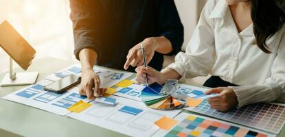 UX developer and ui designer brainstorming about mobile app interface wireframe design with customer breif and color code at office. photo