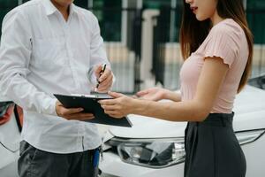 Customers and car insurance agents have entered into agreements and signed documents to claim compensation after on the road in sun light photo