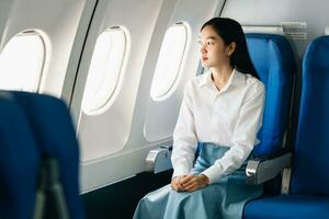 Asian woman sitting in a seat in airplane and looking out the window going on a trip vacation travel concept.Capture the allure of wanderlust with this stunning image photo