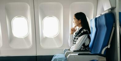 Young Asian executive excels in first class, multitasking with digital tablet, laptop and smartphone. Travel in style, work with grace. in morning light photo