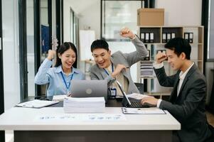 Group of Young Asian business team creative businesspeople coworker, teamwork celebrating achievement and in planning design in creative in officeThose who work hard, win in the conference room photo