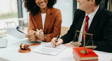 Business and lawyers discussing contract papers with brass scale on desk in office. Law, legal services, advice,  justice and law concept . photo