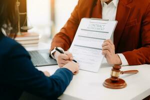 Two lawyers are discussing about contract paper, law matters determination, pointing.law and hammer on the table photo