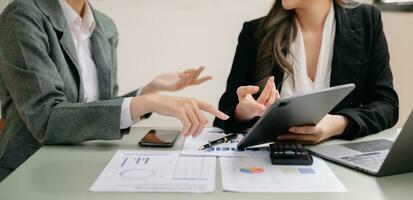 Businessman and team analyzing financial statement Finance task. with smart phone and laptop and  tablet. Wealth management concept photo