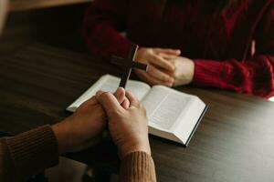 dos personas leyendo y estudiar Biblia en hogar y orar juntos.estudiando el palabra de Dios con amigos. en Dom ligero foto