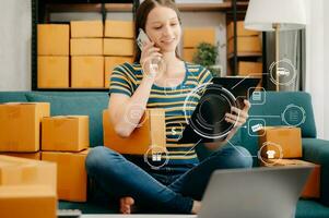 mujer mano utilizando un computadora portátil, teléfono inteligente y tableta y escritura cuaderno a el oficina de su negocio en línea compras. en hogar con virtual icono foto