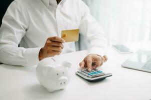 Businessman using calculator with credit card for shopping internet online and financial business strategy in modern office. photo