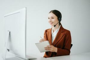 Serious call center operator in wireless headset talking with customer, woman in headphones with microphone consulting client on phone in customer support service in office center photo