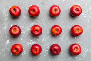 Many red apples on colored background, top view. Autumn pattern with fresh apple above view photo