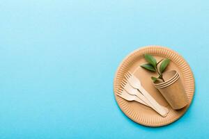 set of empty reusable disposable eco-friendly plates, cups, utensils on light white colored table background. top view. Biodegradable craft dishes. Recycling concept. Close-up photo