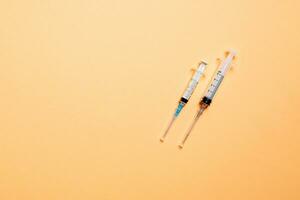 Top view of medical syringes on colorful background with copy space. Injection equipment concept photo