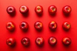 Many red apples on colored background, top view. Autumn pattern with fresh apple above view photo