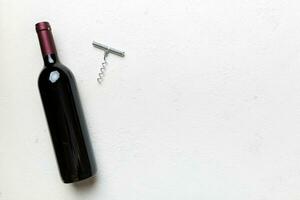 One Bottle of red wine with corkscrew on colored table. Flat lay, top view wth copy space photo