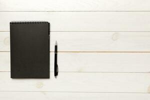 school notebook on a colored background, spiral black notepad on a table Top view photo