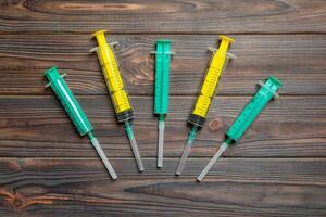 Top view of many syringes prepared for injection at wooden background. Treatment concept with copy space photo