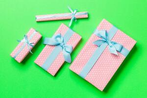 Gift box with blue bow for Christmas or New Year day on green background, top view photo