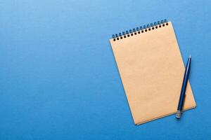 school brown notebook on a colored background, spiral craft notepad on a table Top view photo