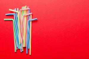 Heap of colorful plastic drinking straws on Colored background, flat lay. Copy Space for text photo