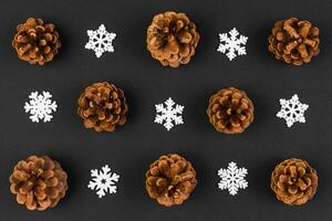 Top view of holiday composition made of pine cones and white snowflakes on colorful background. Winter time and Christmas concept with copy space photo