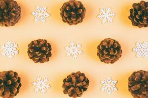 Top view of holiday composition made of pine cones and white snowflakes on colorful background. Winter time and Christmas concept with copy space photo