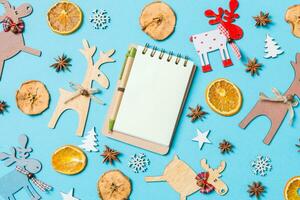 Top view of notebook on blue background made of holiday decorations and toys. Christmas ornament concept photo