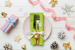 Christmas table place setting with christmas decor and plates, kine, fork and spoon. Christmas holiday background. Top view photo