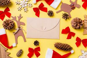 Christmas yellow background with holiday toys and decorations. Top view of craft envelope. Happy New Year concept photo