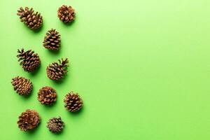 Christmas pine cones on colored paper border composition. Christmas, New Year, winter concept. Flat lay, top view, copy space photo