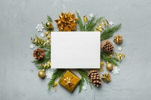 Flat lay Christmas composition. square Paper blank, pine tree branches, christmas decorations on Colored background. Top view, copy space for text photo