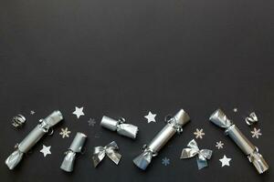 Christmas crackers with shiny confetti on color background, top view, copy space photo