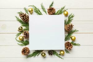 Flat lay Christmas composition. square Paper blank, pine tree branches, christmas decorations on Colored background. Top view, copy space for text photo