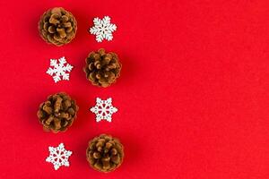 Top view of holiday composition made of pine cones and white snowflakes on colorful background. Winter time and Christmas concept with copy space photo