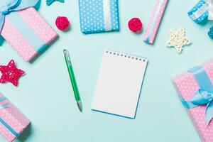 Top view of notebook on blue background made of Christmas decorations. New Year time concept photo