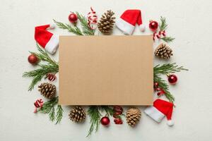 Flat lay Christmas composition. square Paper blank, pine tree branches, christmas decorations on Colored background. Top view, copy space for text photo